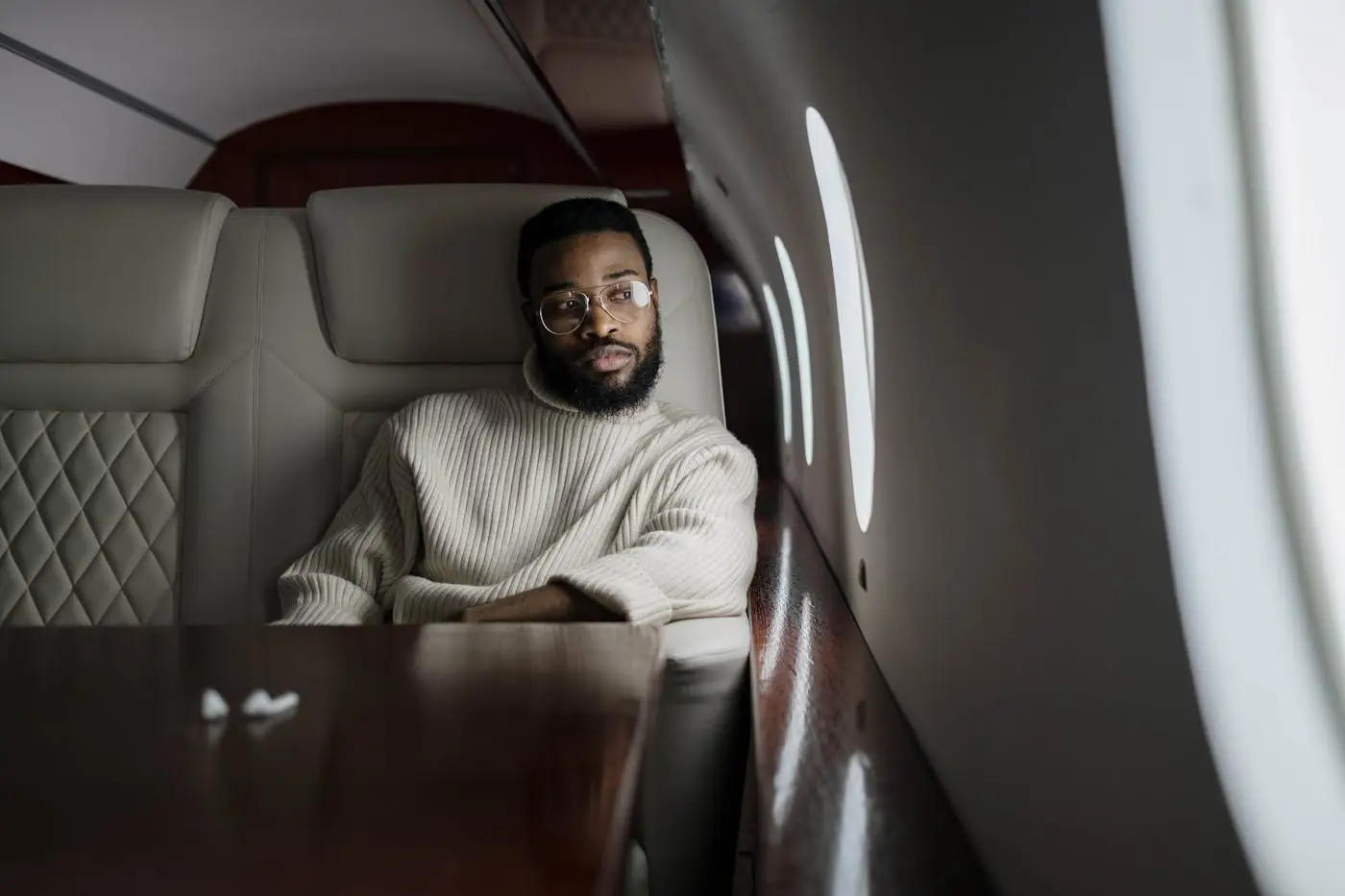 Passager installé près du hublot dans la cabine d’un jet privé au départ d’Abidjan